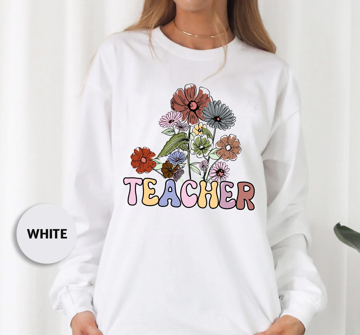 a woman wearing a white sweatshirt with flowers on it