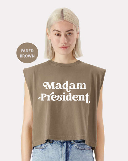 a woman with blonde hair wearing a brown shirt that says madam president