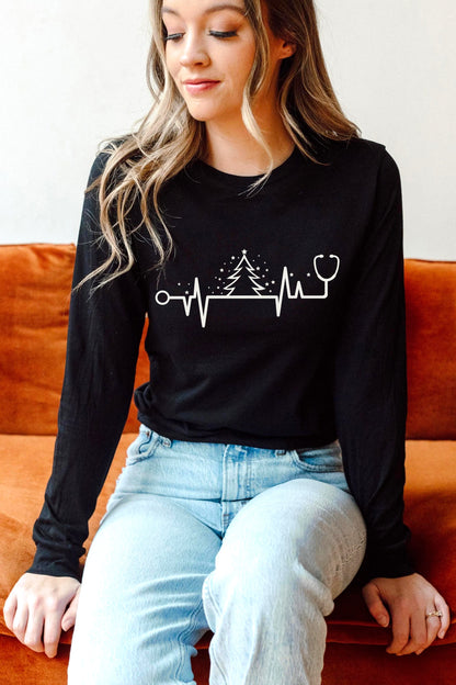 A woman wearing a black long-sleeved shirt with a white graphic design sits on an orange couch.