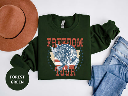 a green sweatshirt with a graphic design featuring an eagle and the word "FREEDOM" printed on it, along with a brown hat and blue jeans.