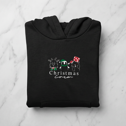 A black hoodie with a graphic design featuring three cartoon animal characters and the text "Christmas crew" printed on it.