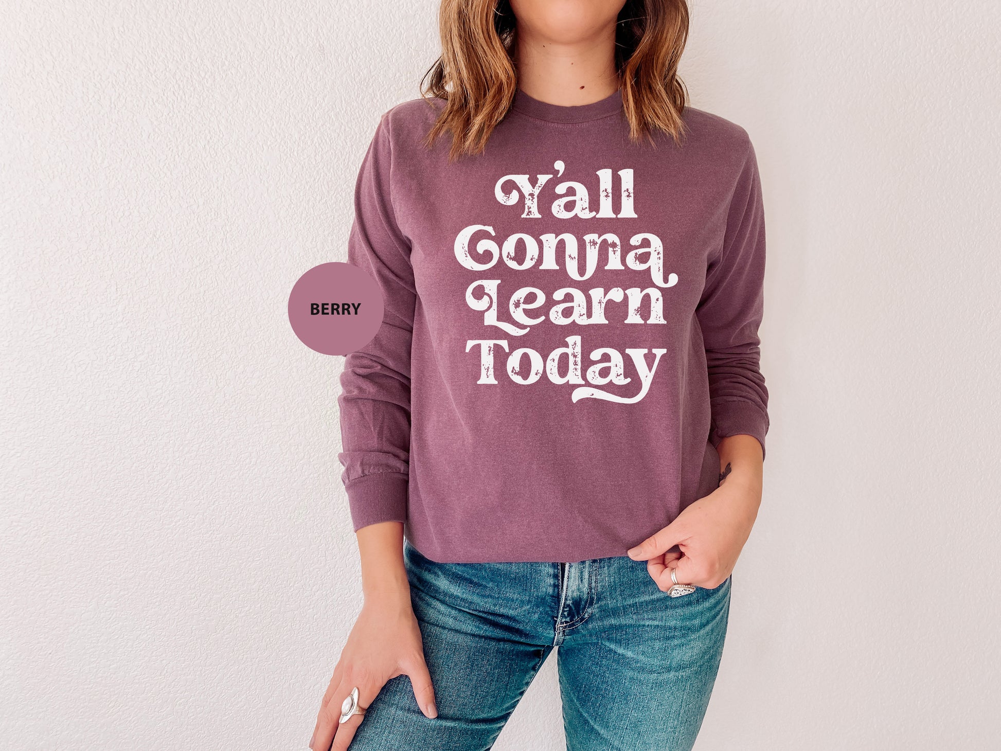 a woman wearing a sweater that says y'all comma learn today