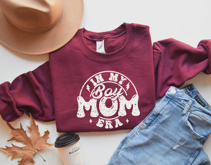 a woman wearing a sweatshirt with the word mom of the year printed on it