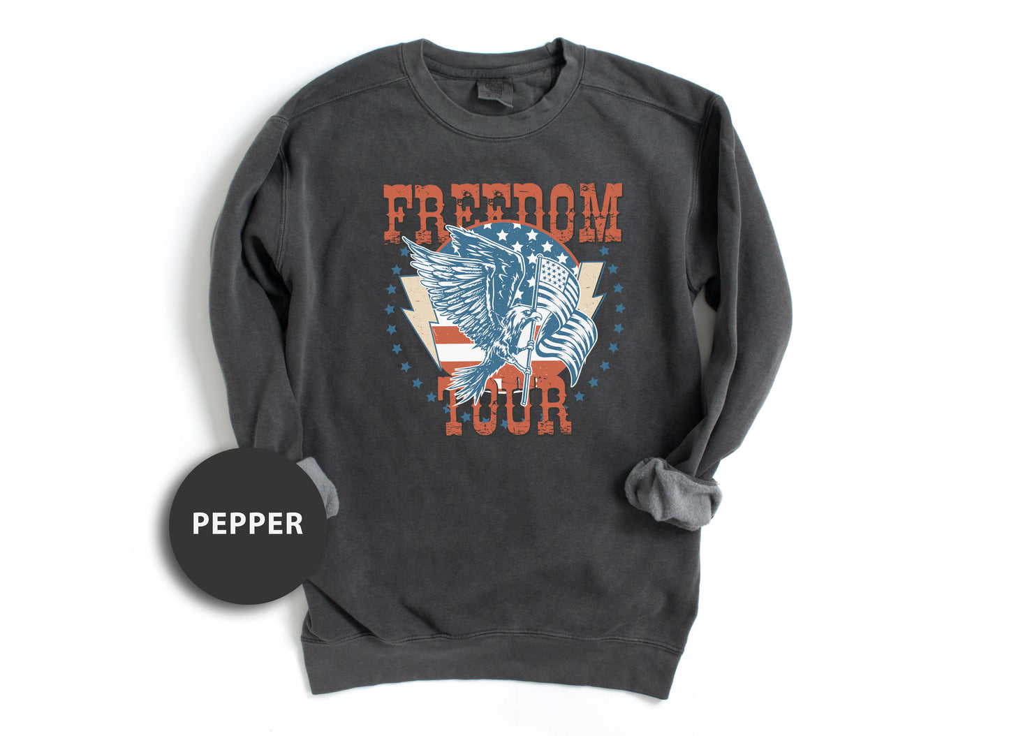 A gray sweatshirt with a graphic design featuring an eagle and the text "FREEDOM TOUR" printed on it.