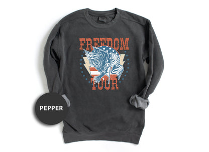 A gray sweatshirt with a graphic design featuring an eagle and the text "FREEDOM TOUR" printed on it.