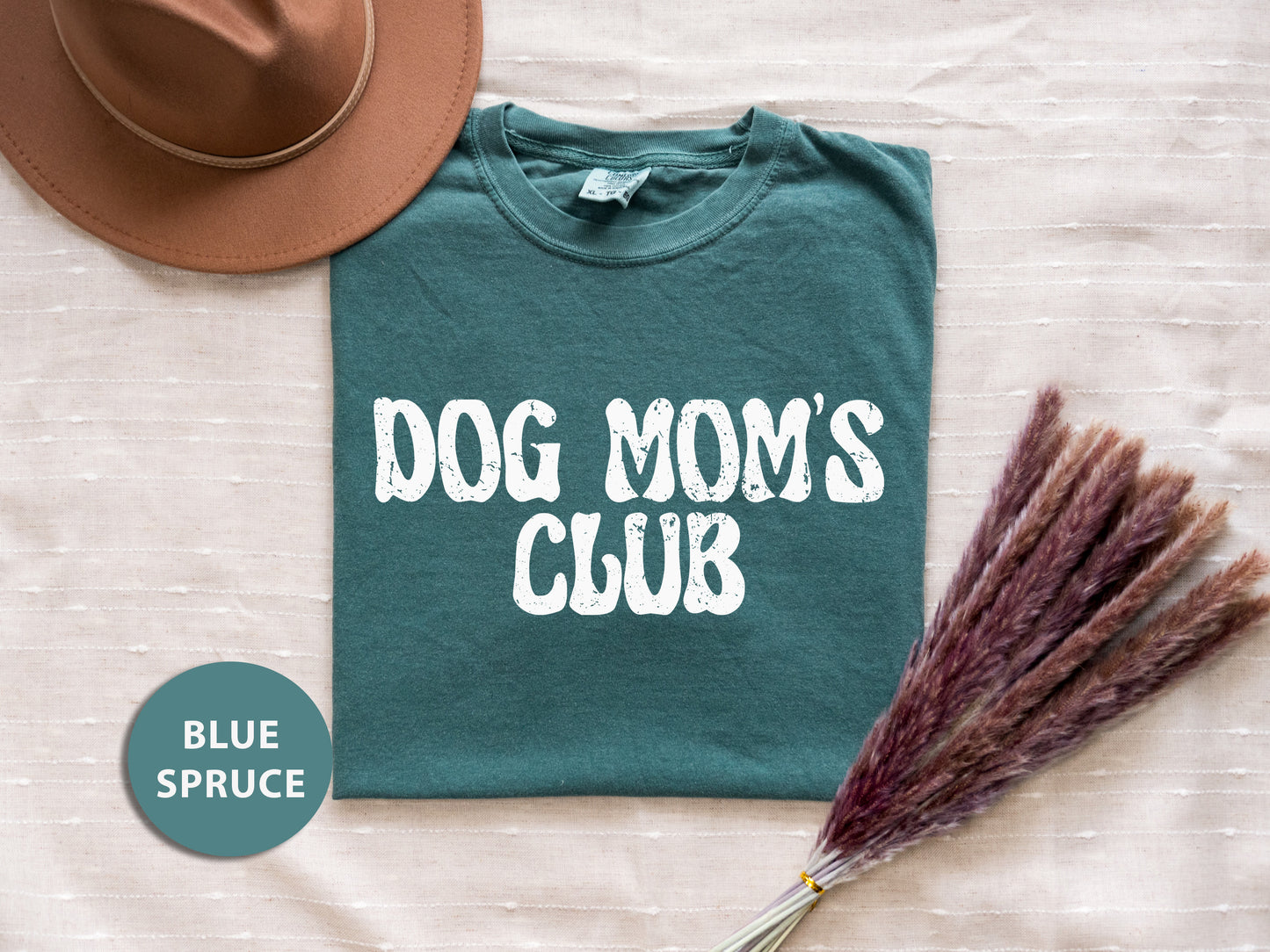 a t - shirt that says dog mom's club next to a hat and