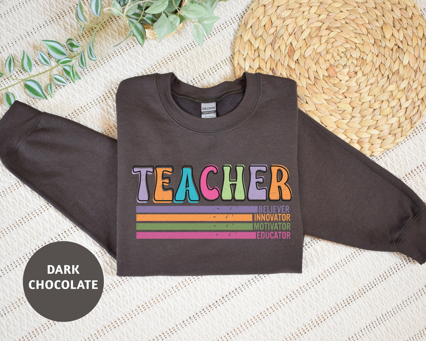 a shirt that says teacher on it next to a straw hat