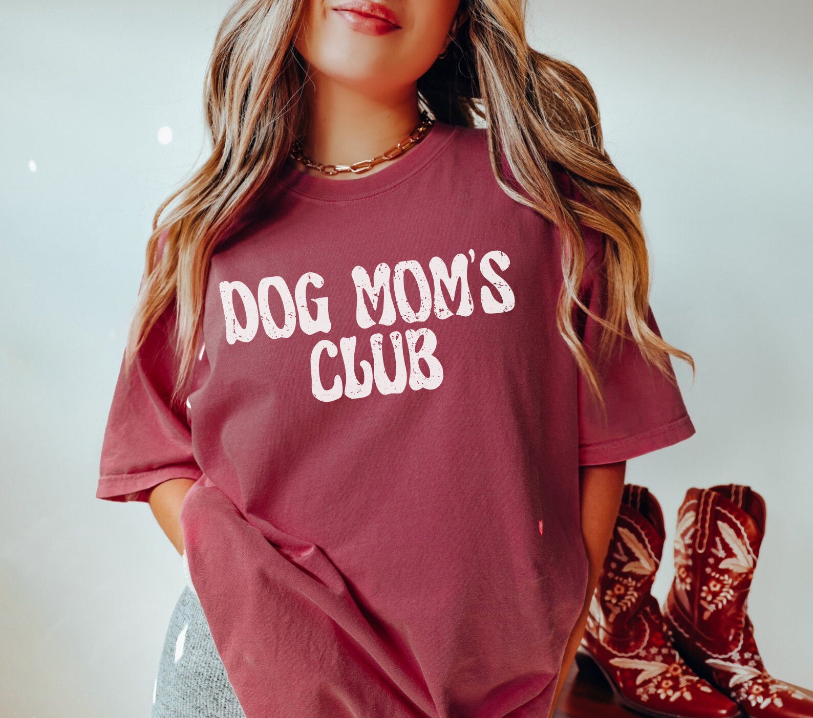 a woman wearing a dog mom's club t - shirt