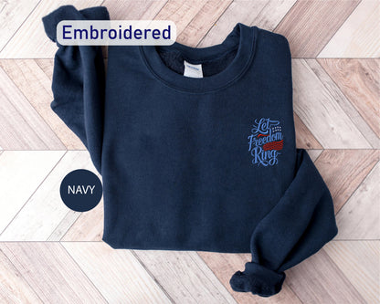 A navy blue sweatshirt with an embroidered design on the left side, labeled as "Embroidered" and "Let's fight for freedom".