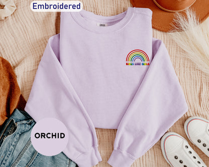 a purple shirt with a rainbow embroidered on it