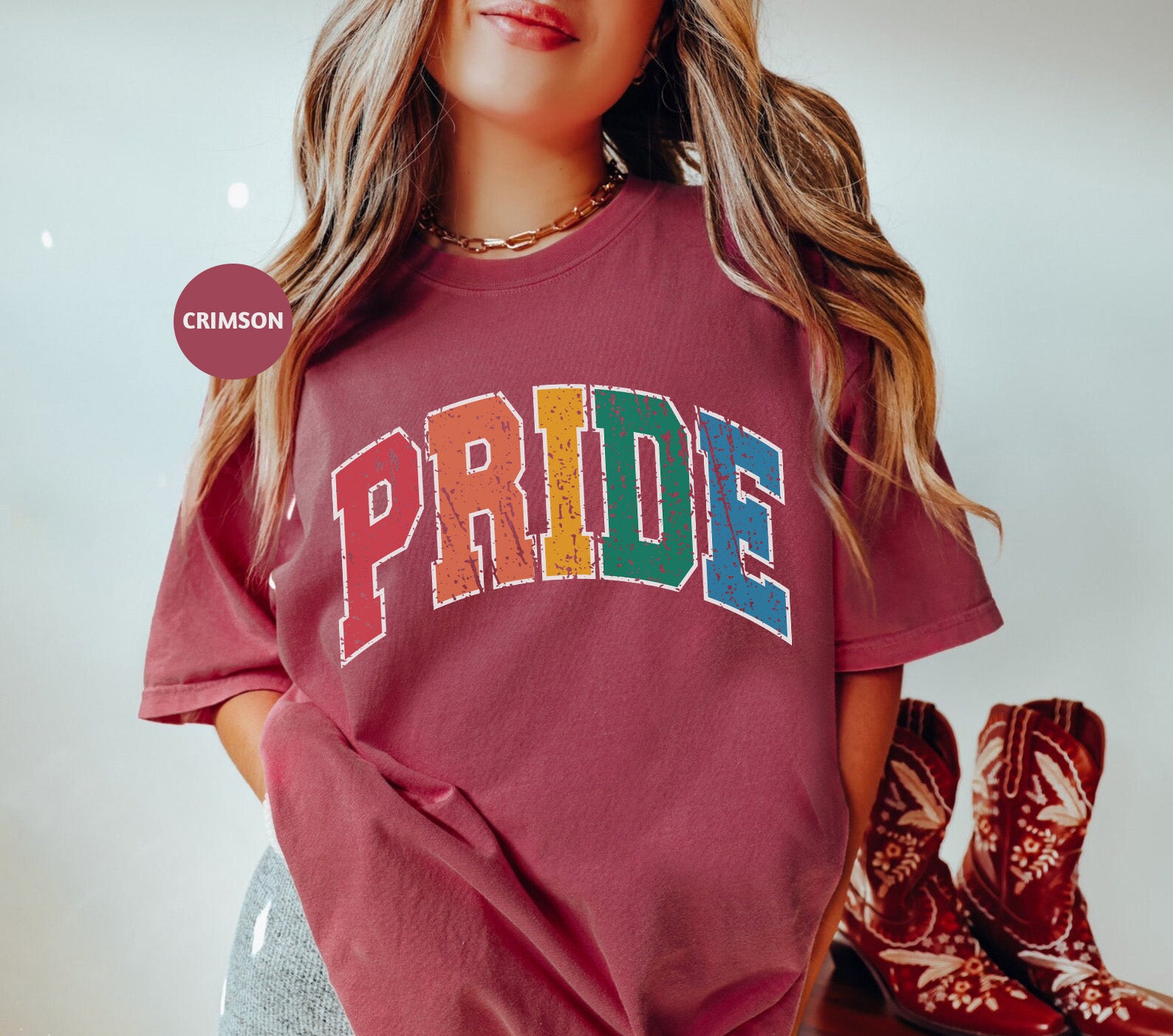 a woman wearing a red shirt with the word pride on it