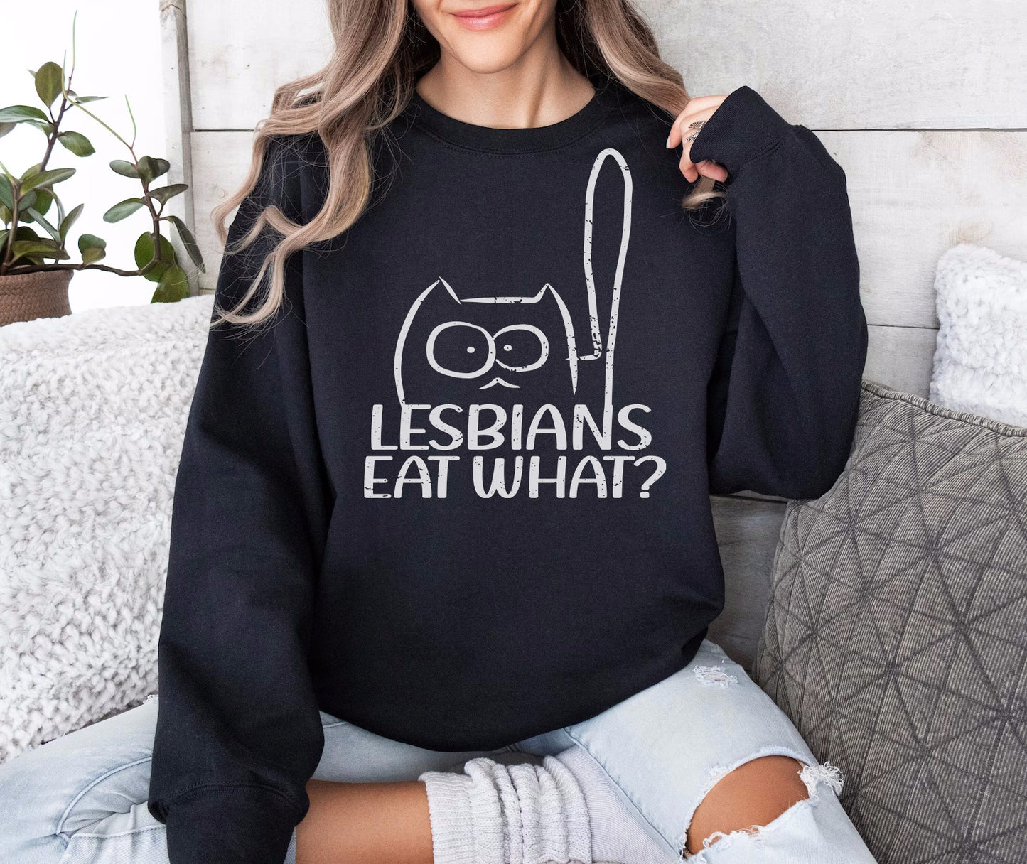 a woman wearing a black sweatshirt that says lesbians eat what?