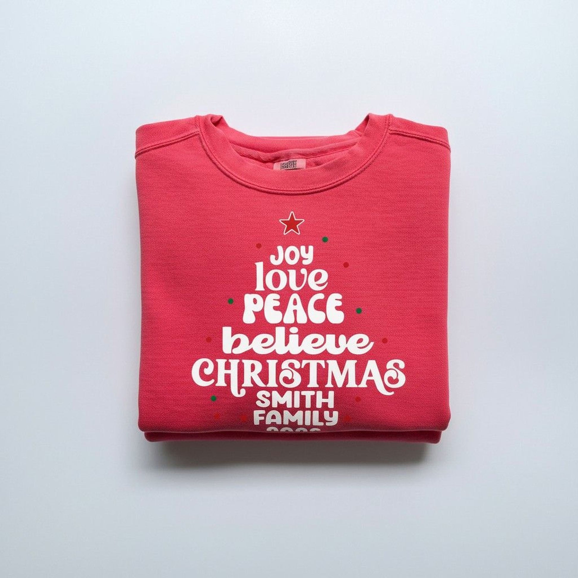 A red sweatshirt with white text printed on it, folded over itself.