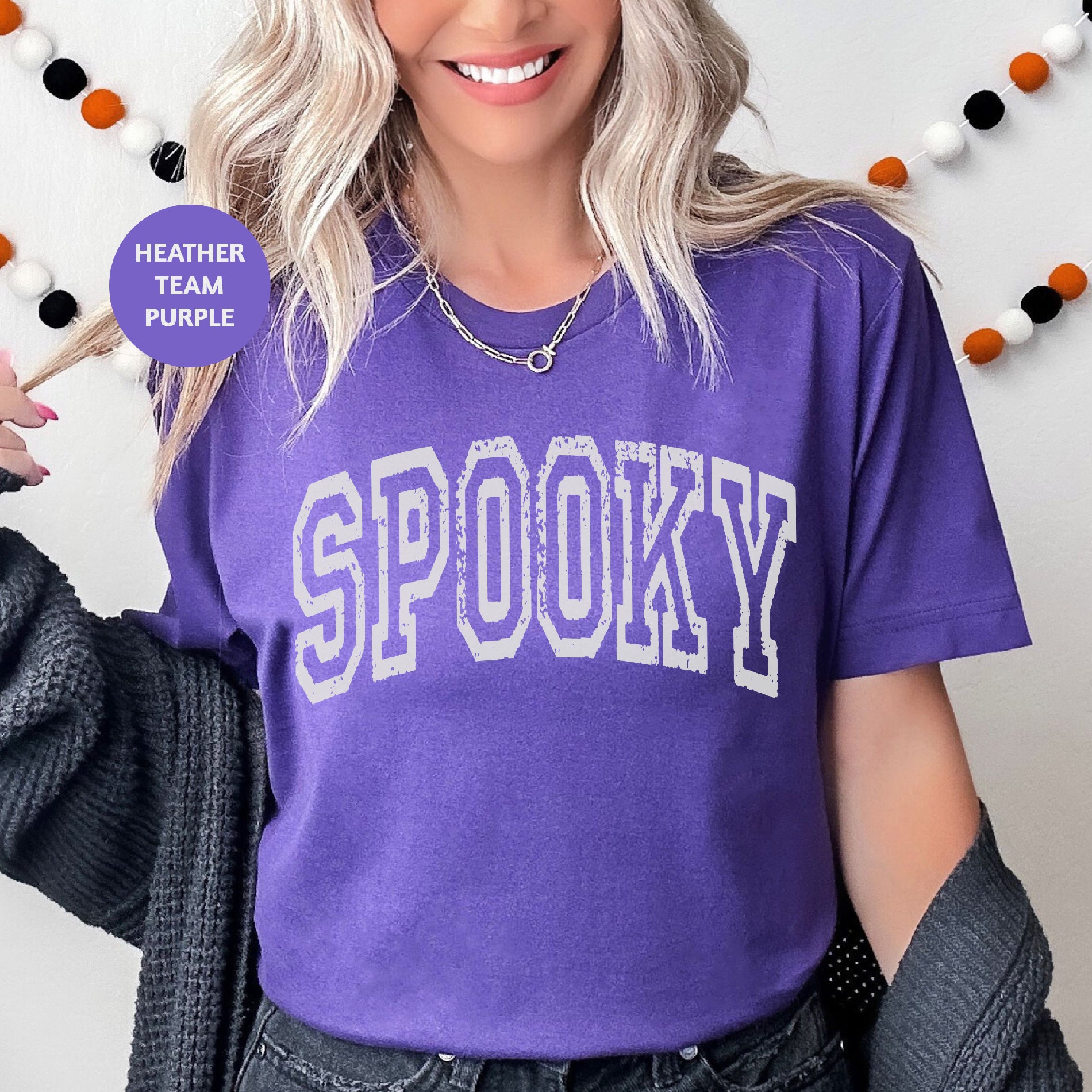 a woman wearing a purple shirt with the word spooky on it