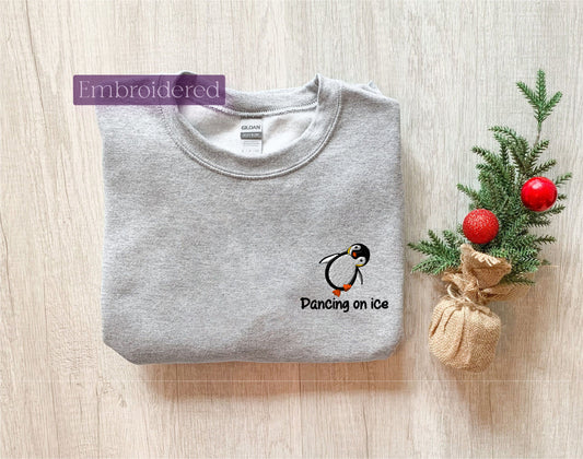 a t - shirt with a penguin on it next to a christmas tree