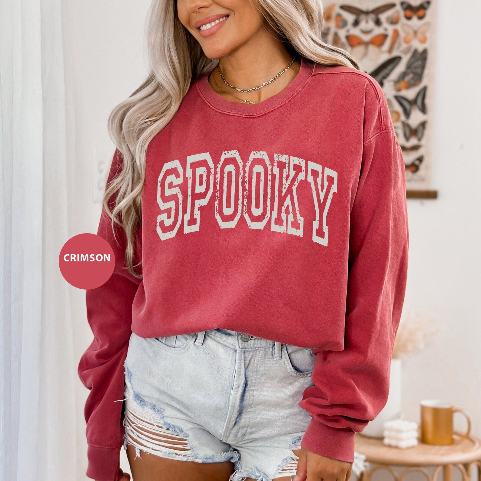 a woman wearing a red sweatshirt with the word spooky on it