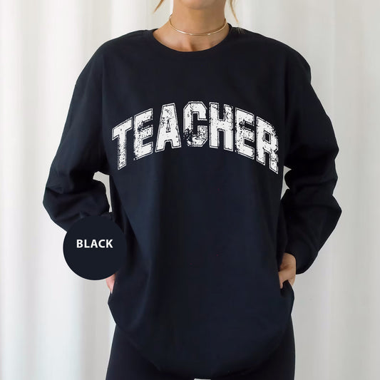 a woman wearing a black sweatshirt with the word teacher printed on it