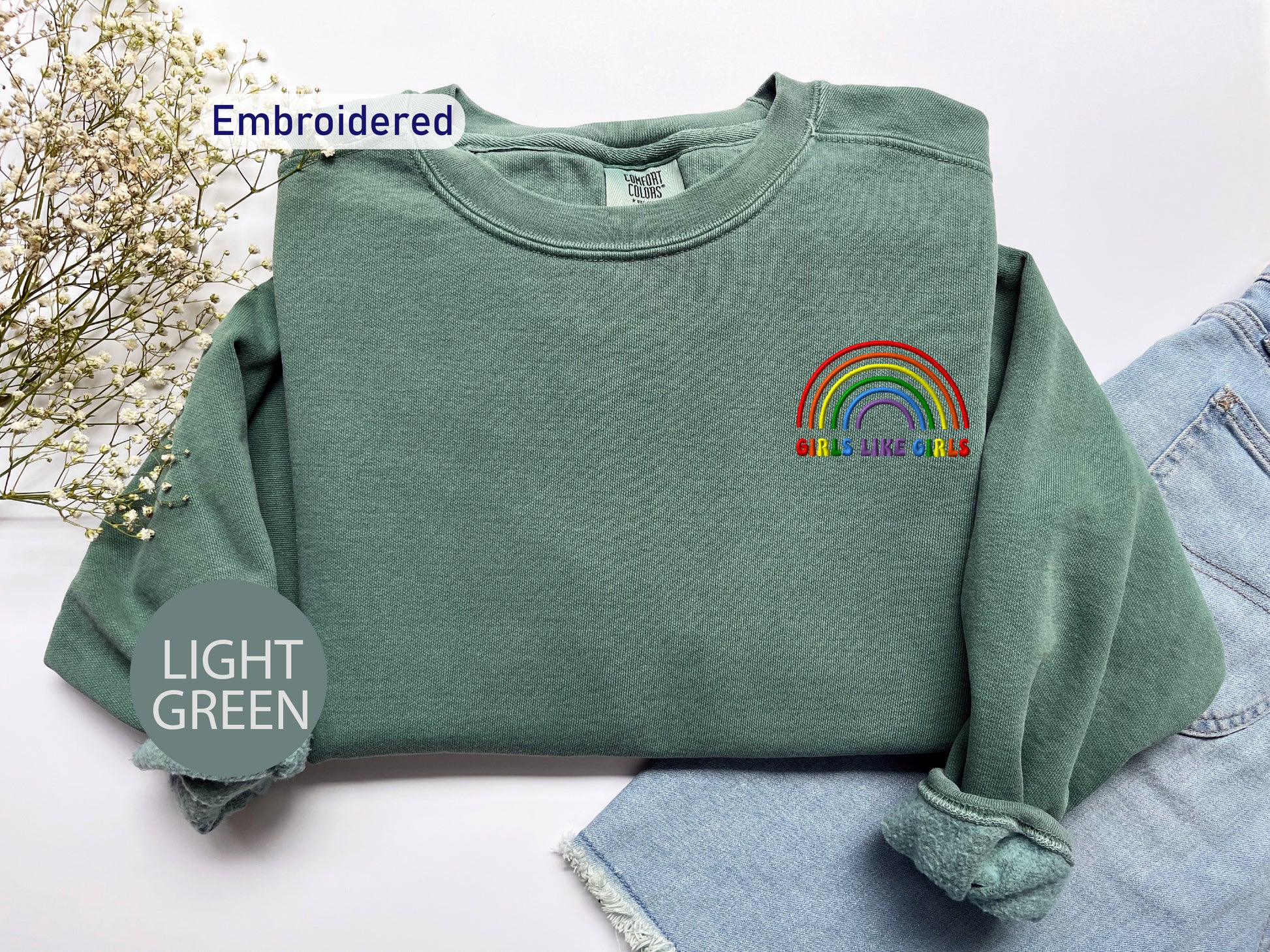 a green sweatshirt with a rainbow embroidered on it