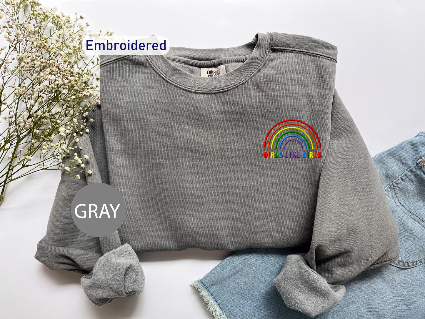 a gray sweatshirt with a rainbow embroidered on it