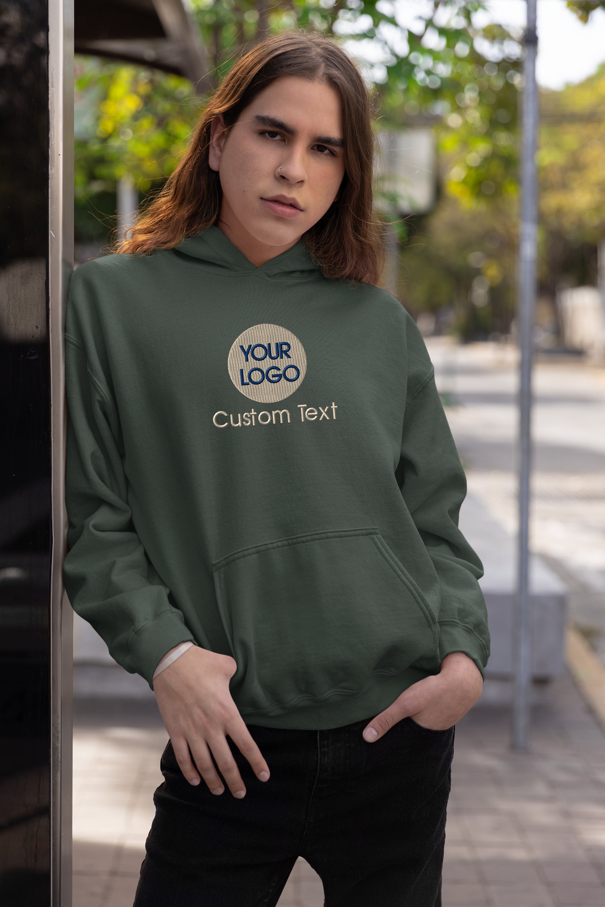 a woman in a green hoodie stands on a sidewalk