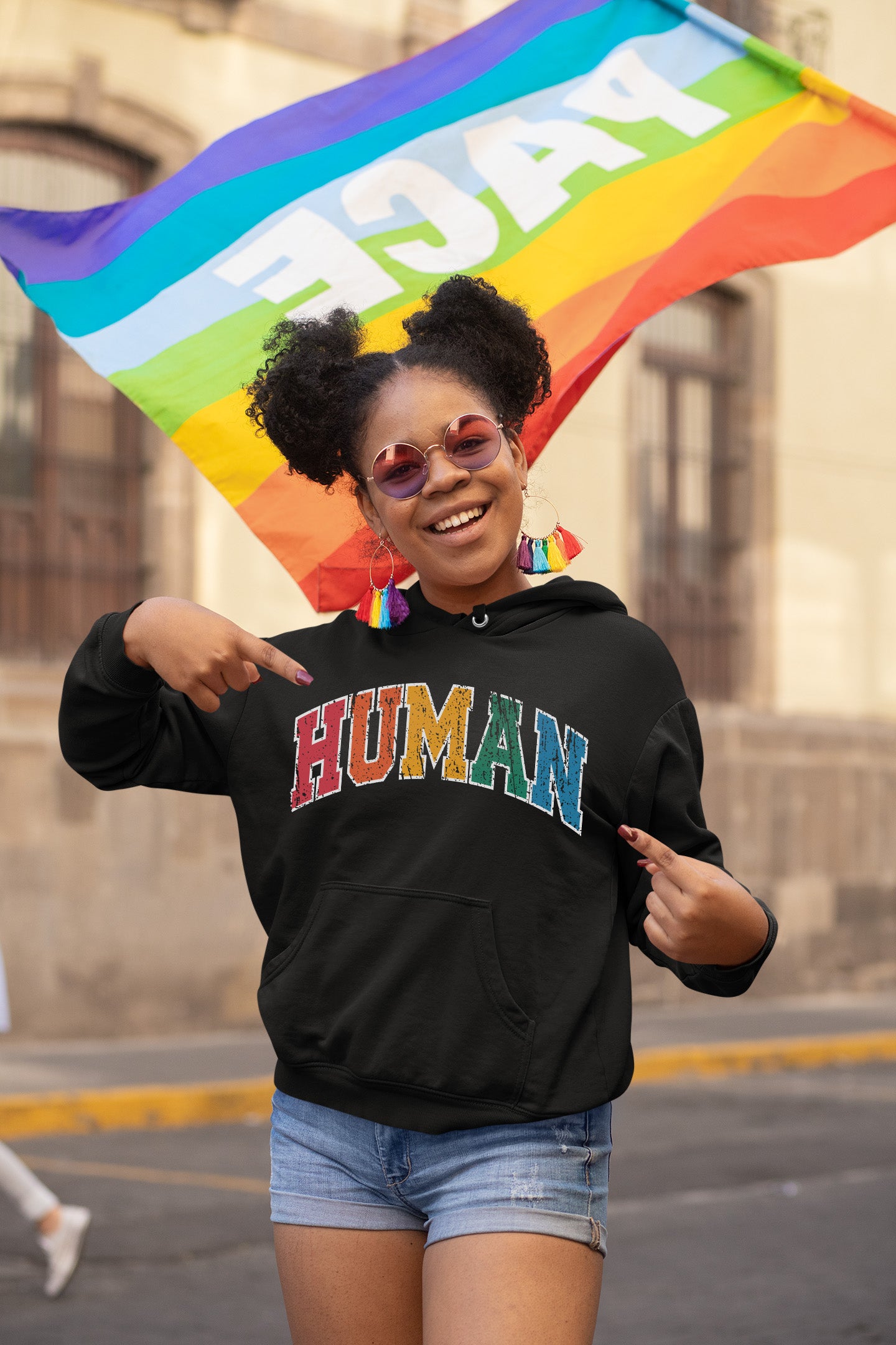 a woman holding a rainbow flag and smiling