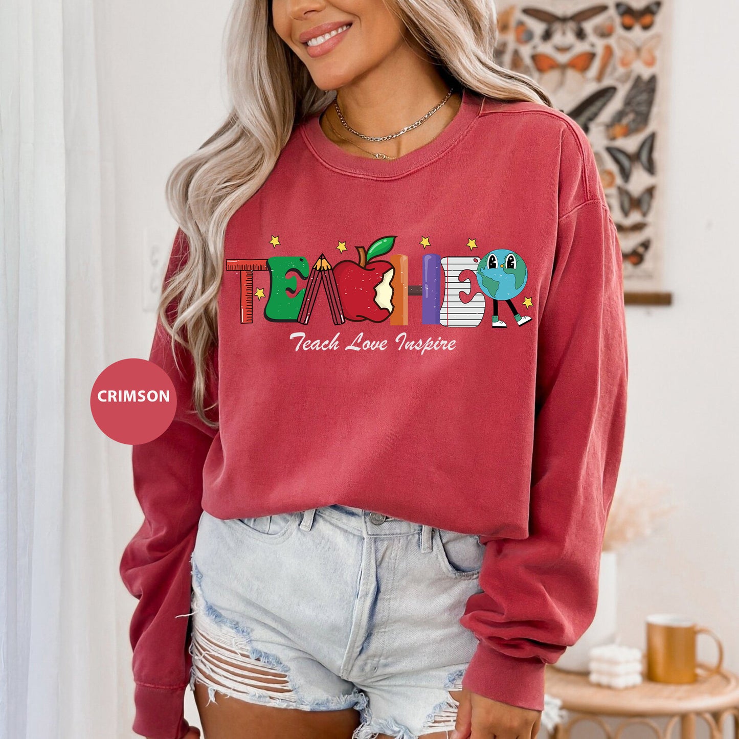 a woman wearing a red sweatshirt with the word teach on it