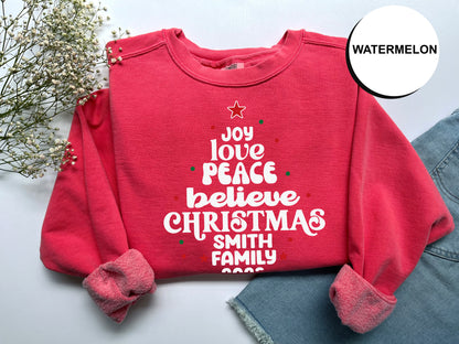 A red sweater with white text and a star on it, along with some flowers and a denim skirt, is displayed on a white background.