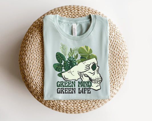 a green mind t - shirt sitting on top of a wicker basket