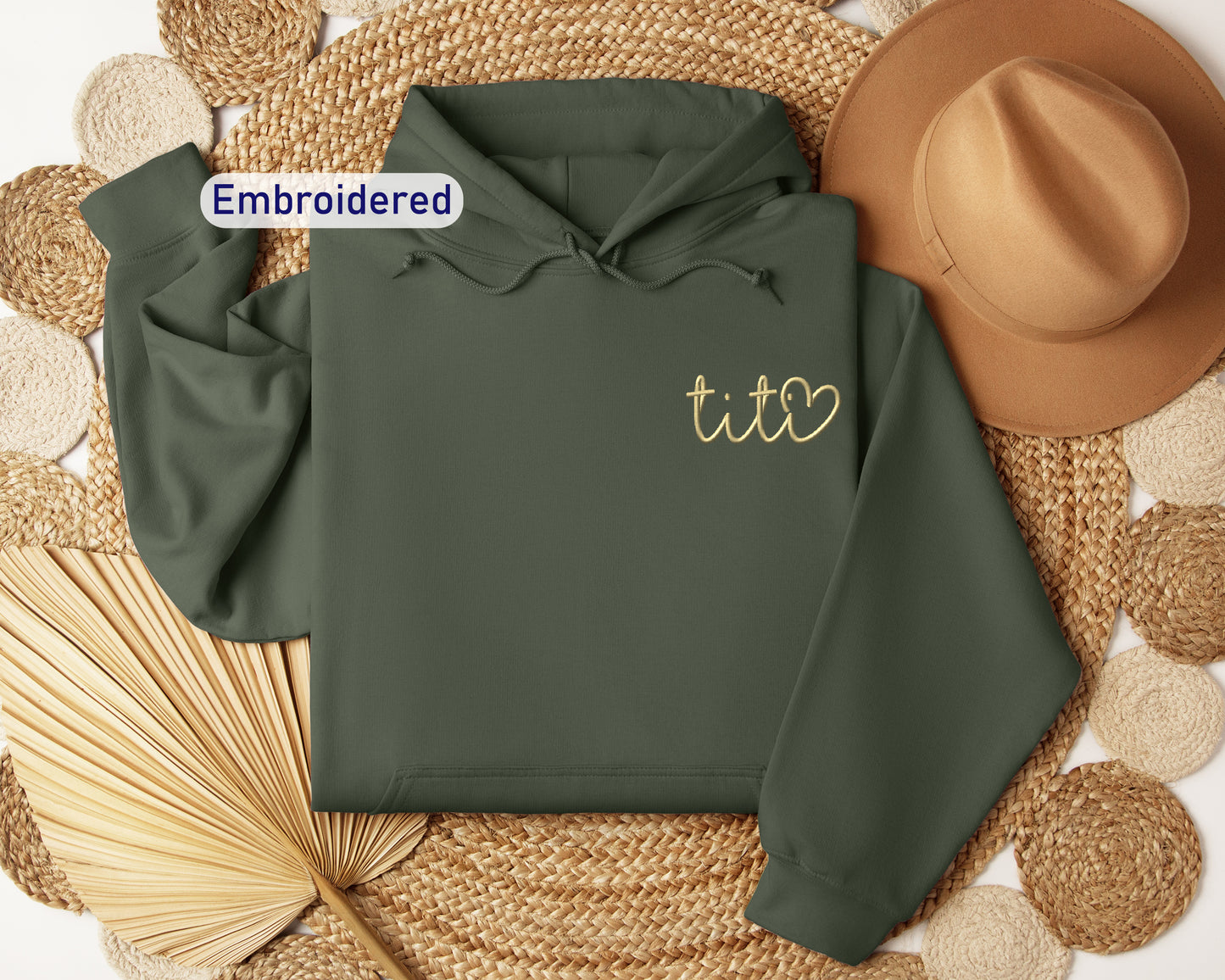 a green hoodie with embroidered tico on it