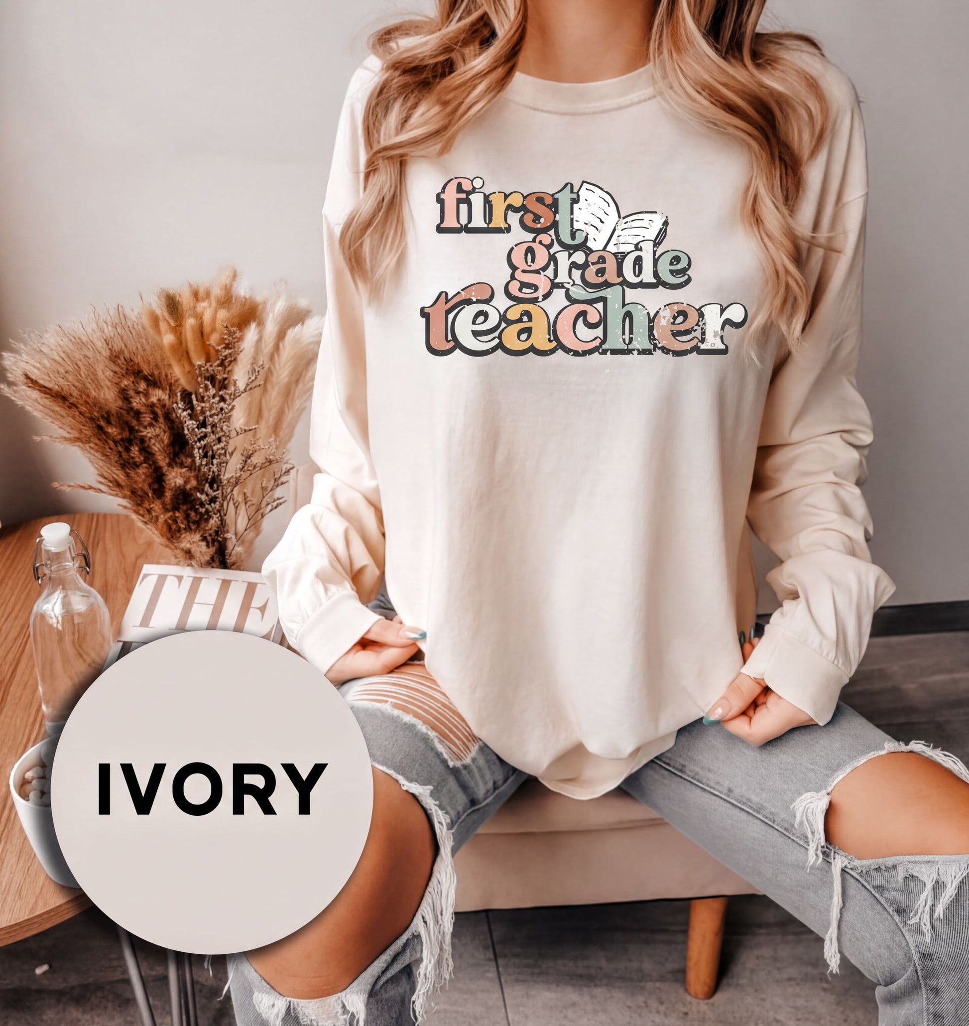 A woman wearing a white long-sleeved shirt with text and graphics printed on it, sitting on a chair.