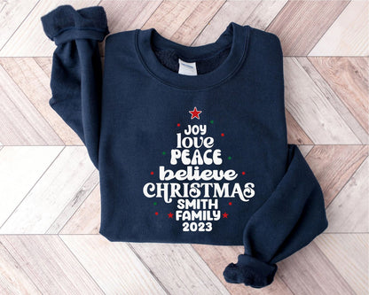 A navy blue sweatshirt with white text and a red star on the front, laid out on a wooden surface.