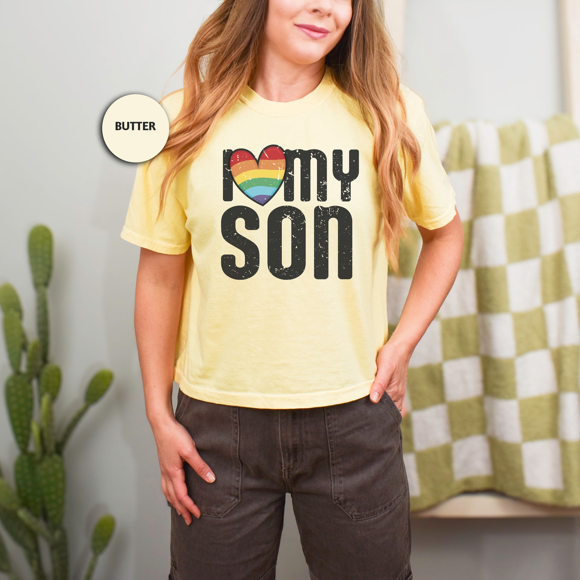 a woman wearing a yellow shirt with the words mom son on it