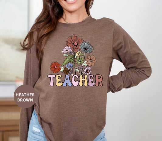 a woman wearing a brown teacher shirt with flowers on it