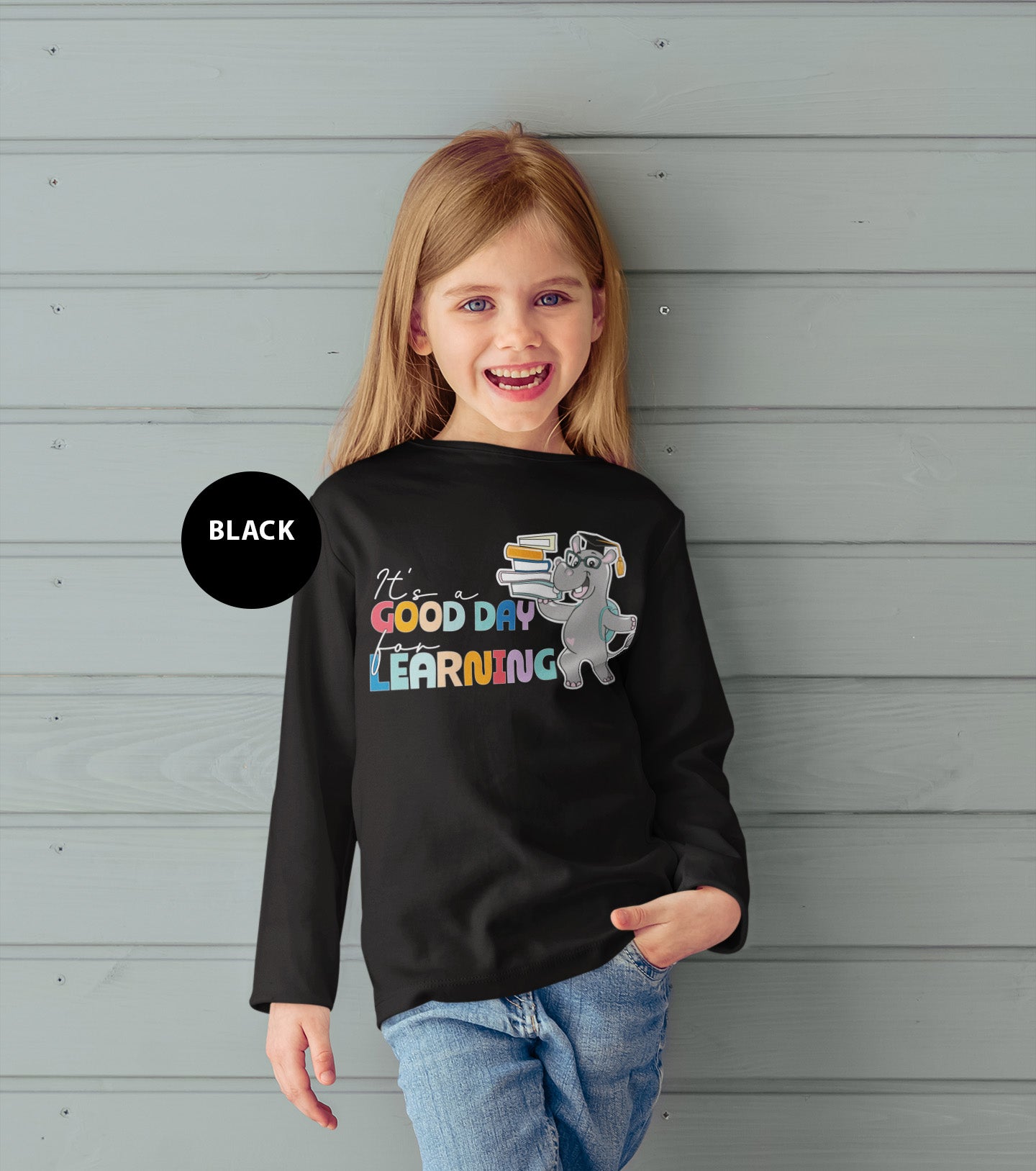 a little girl wearing a black shirt that says good day learning