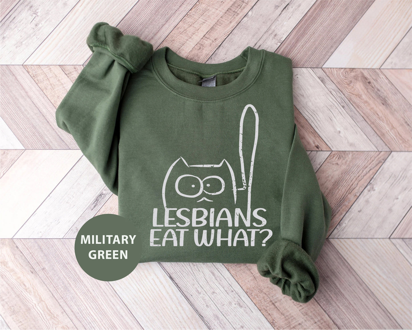 a green sweatshirt with an image of a cat that says lesbians eat what?