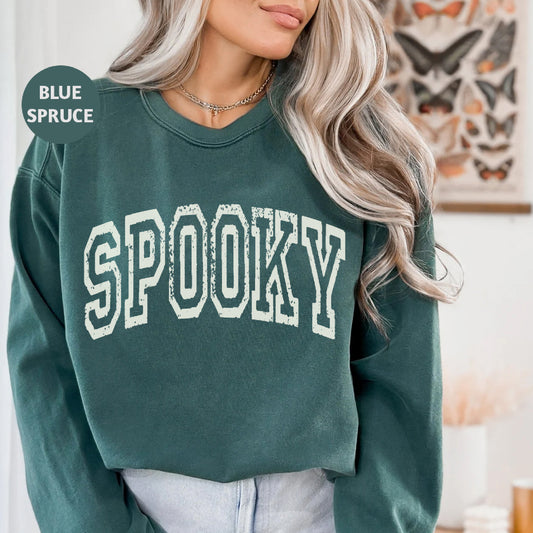 a woman wearing a green sweatshirt with the word spooky on it