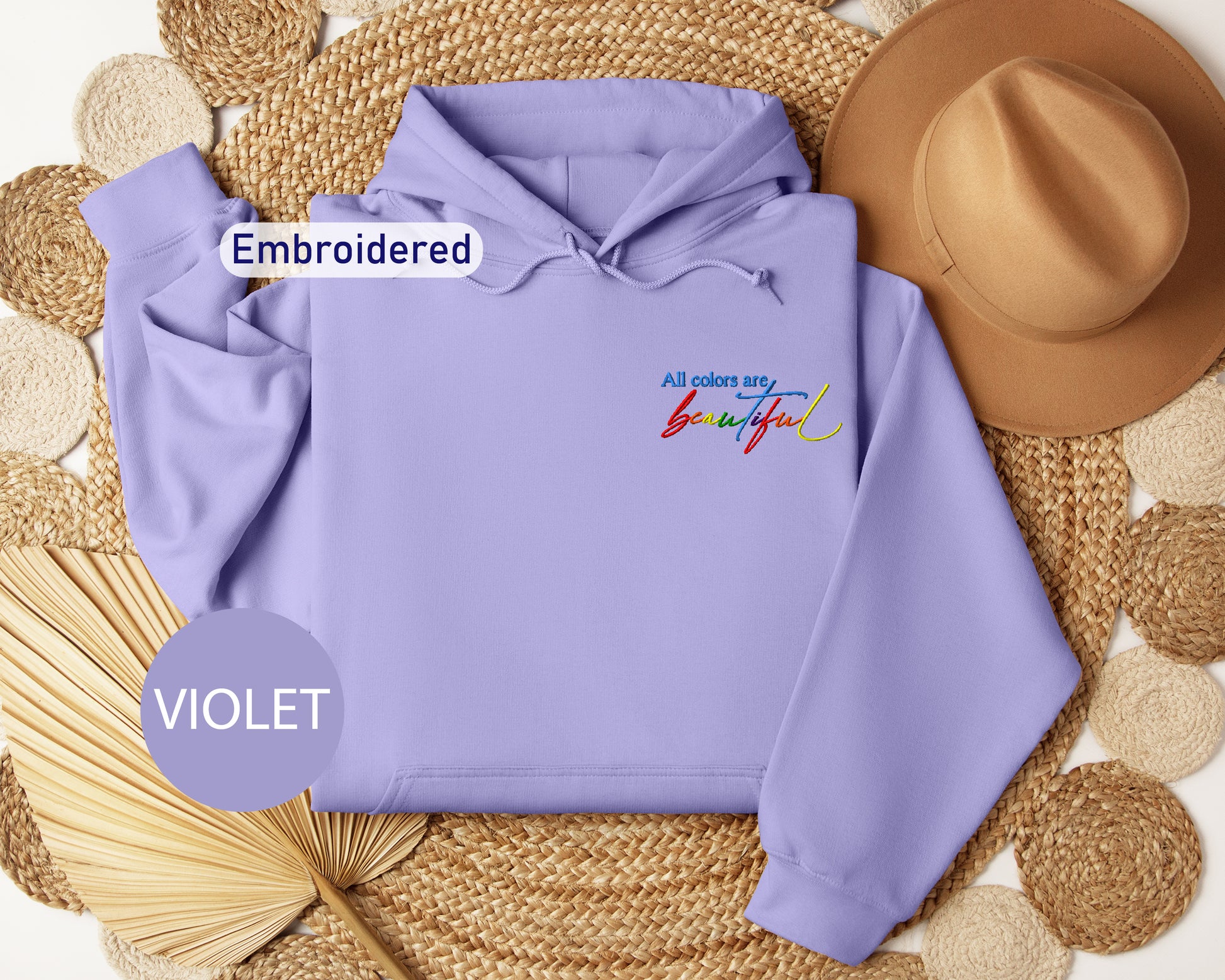 a purple hoodie with embroidered words and a straw hat