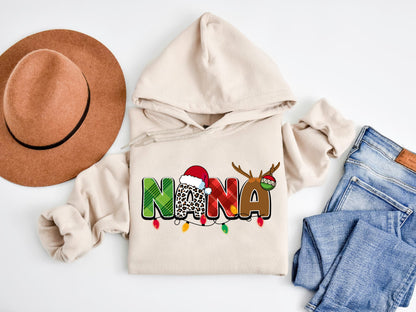 A beige hoodie with a Christmas-themed design, a brown hat, a pair of jeans, and a pair of socks are arranged on a white background.