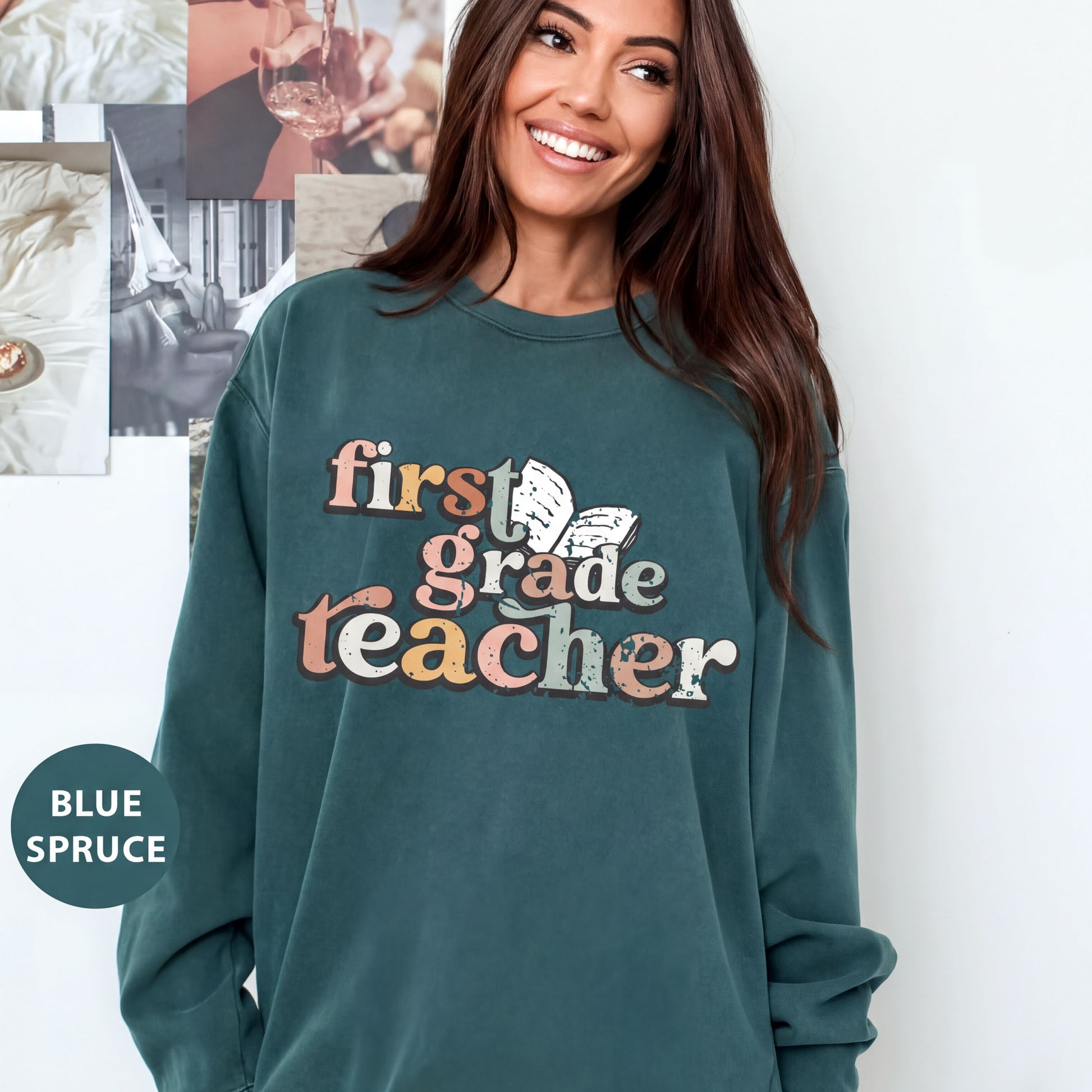 A woman wearing a green sweatshirt with the text "first grade teacher" printed on it, smiling and posing for the camera.