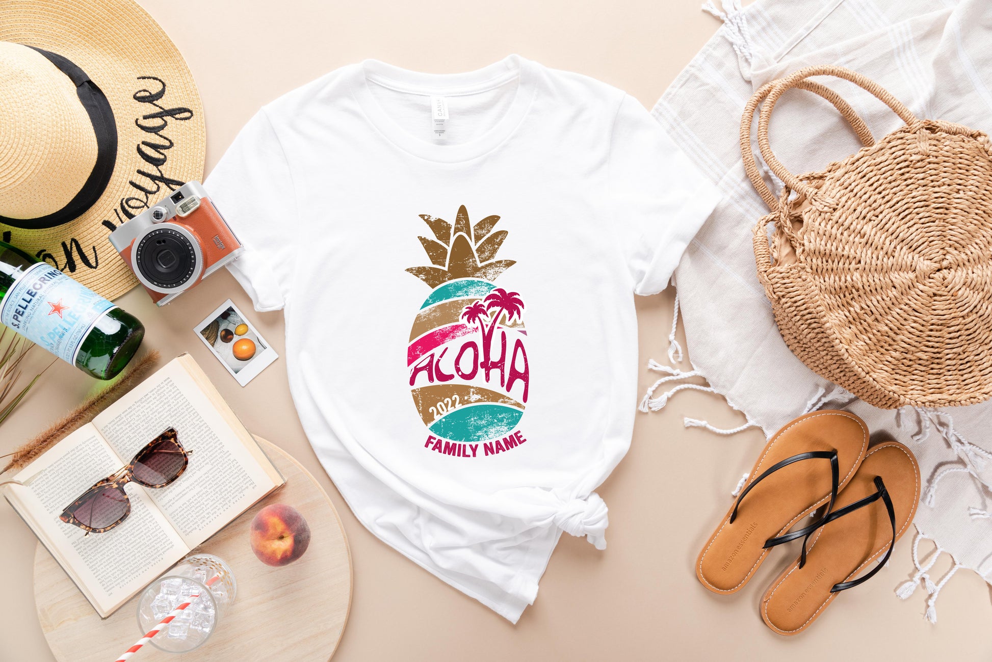 a collection of summer-themed items, including a white t-shirt with a pineapple graphic, sunglasses, a straw hat, a camera, a book, a bottle, a glass, and a pair of sandals.