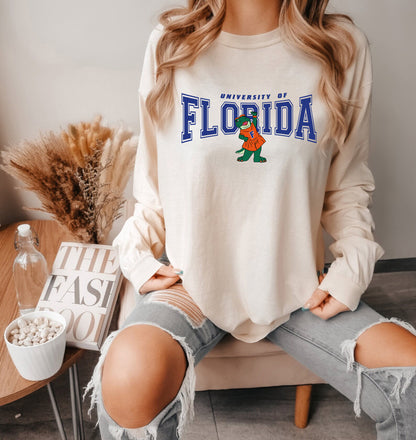 a woman sitting on a couch wearing a florida sweatshirt