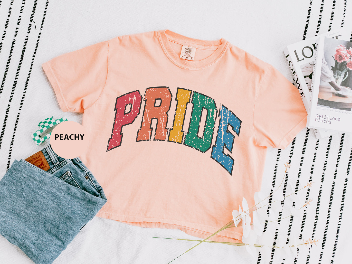 a t - shirt with the word pride on it next to a pair of jeans