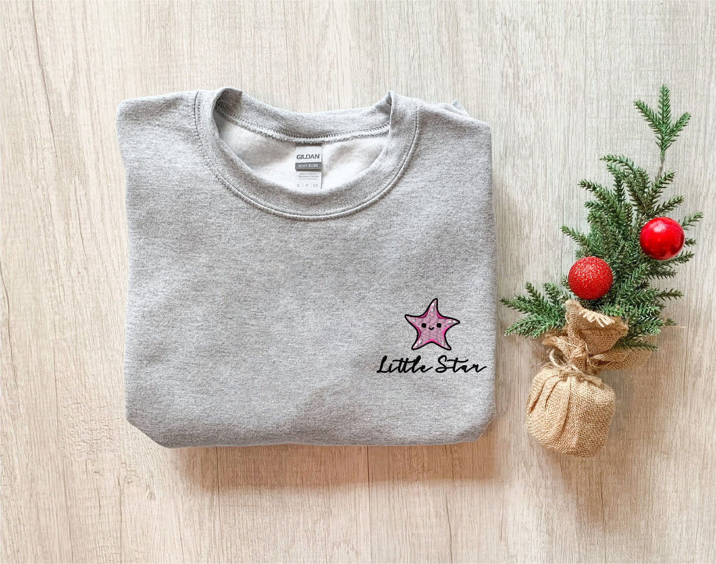 a little star t - shirt next to a small christmas tree