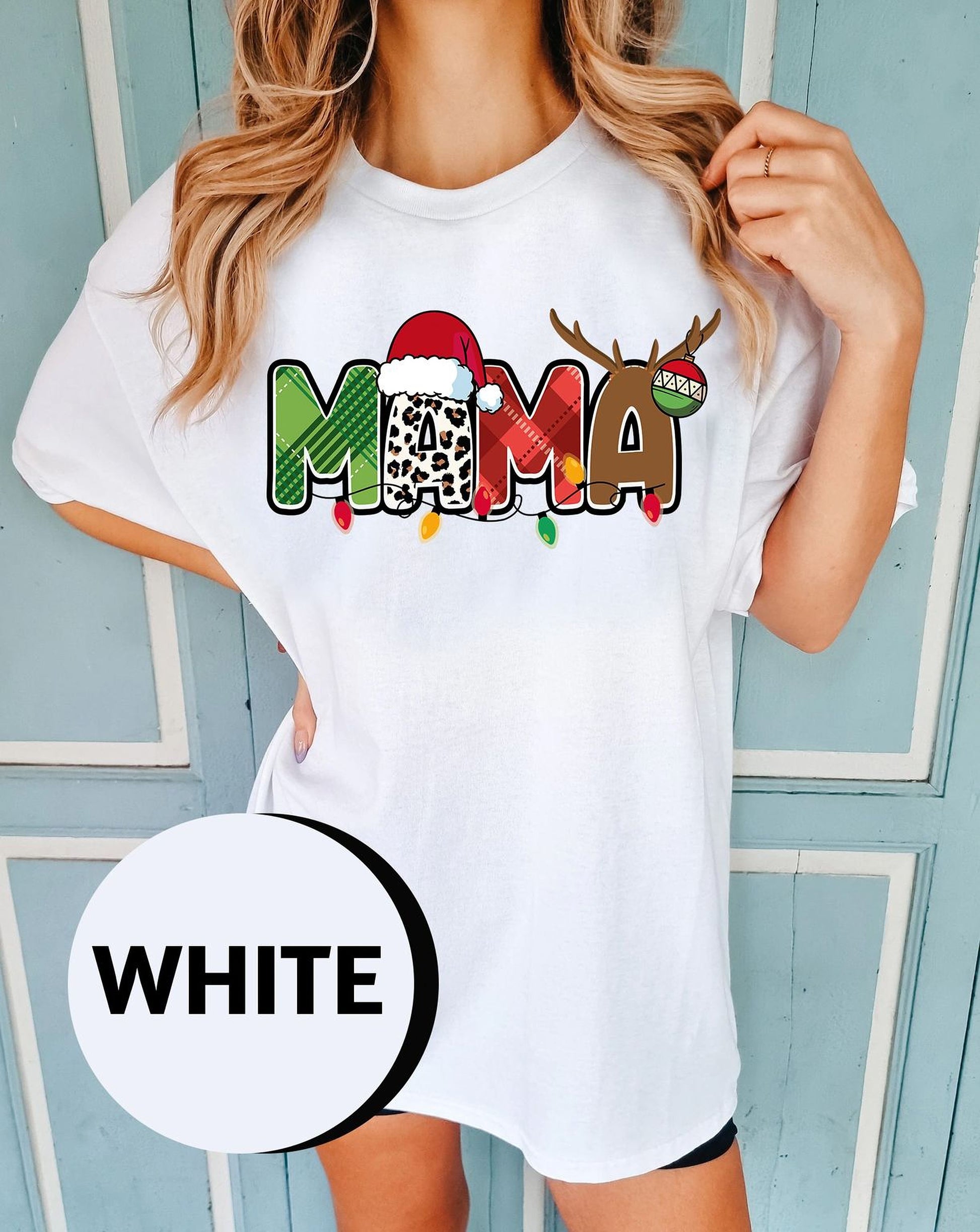 A woman wearing a white t-shirt with a colorful graphic design featuring the word "MAMA" and a reindeer.