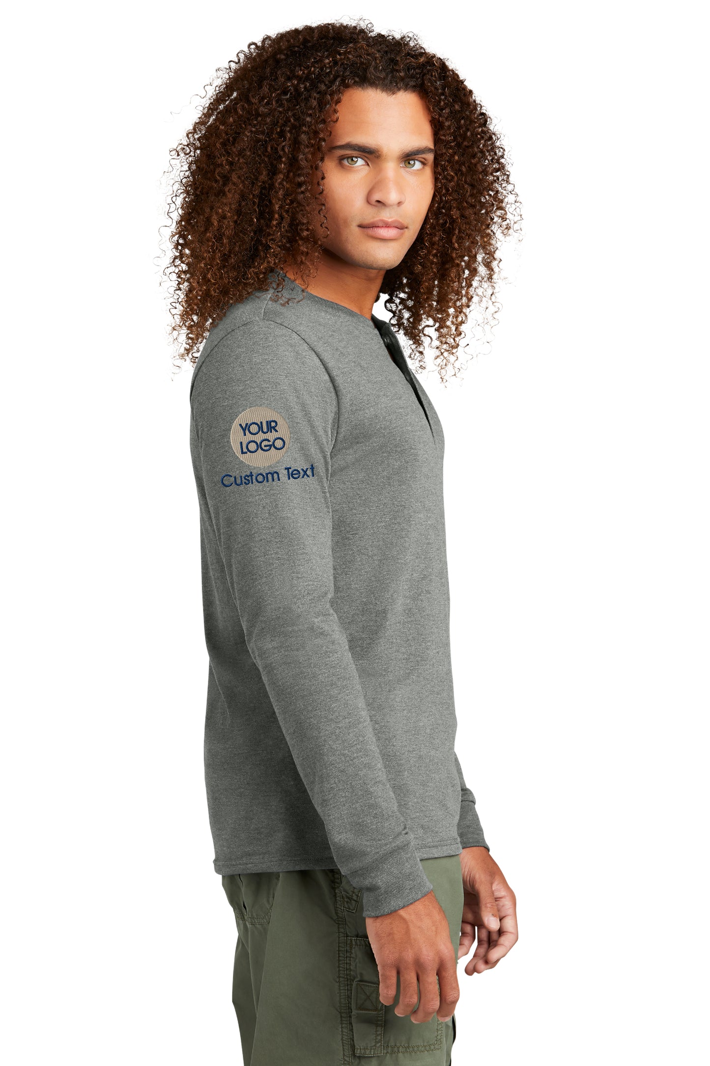 a man with curly hair wearing a grey sweatshirt