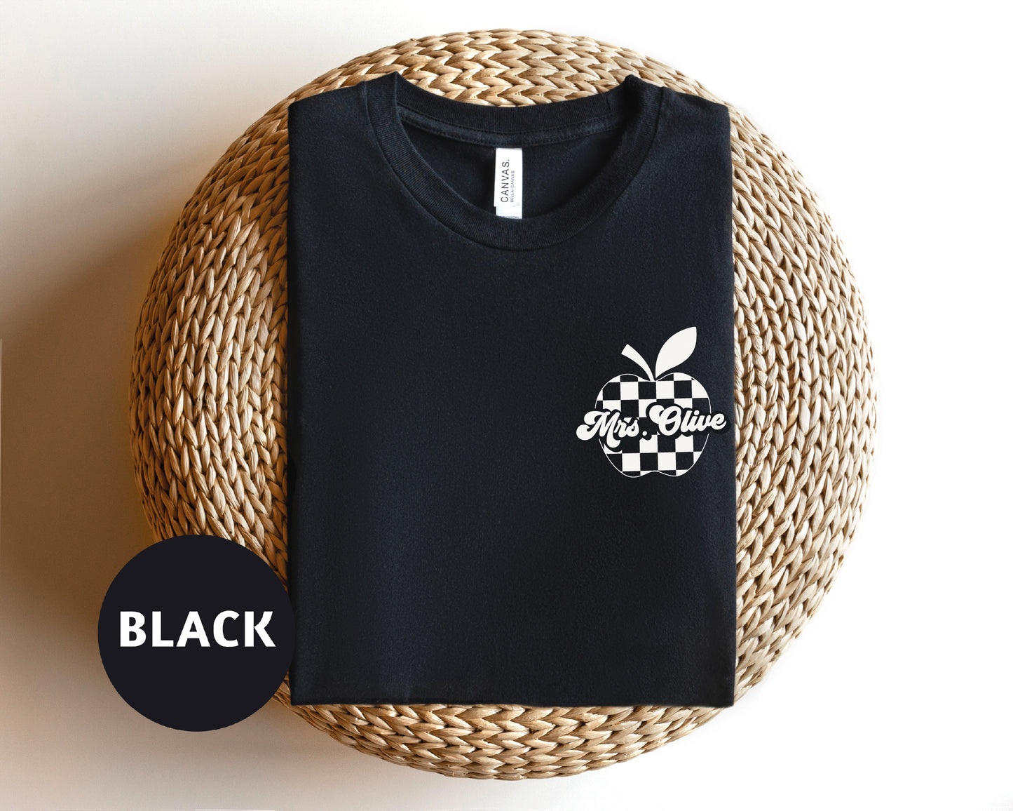 a black t - shirt sitting on top of a wicker basket