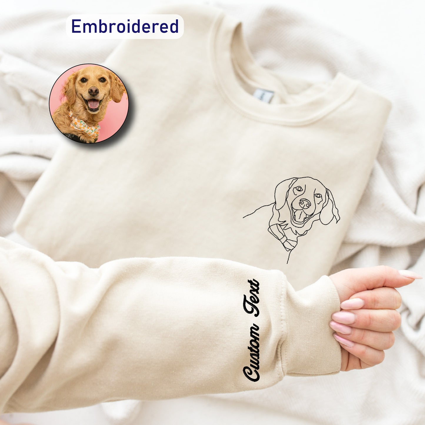 a woman's hand holding a dog sweater with a picture of a dog on