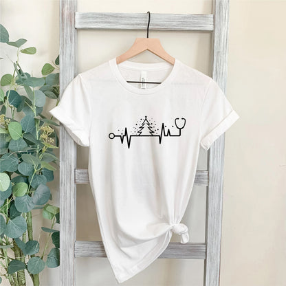 A white t-shirt with a graphic design on it, hanging on a wooden hanger.