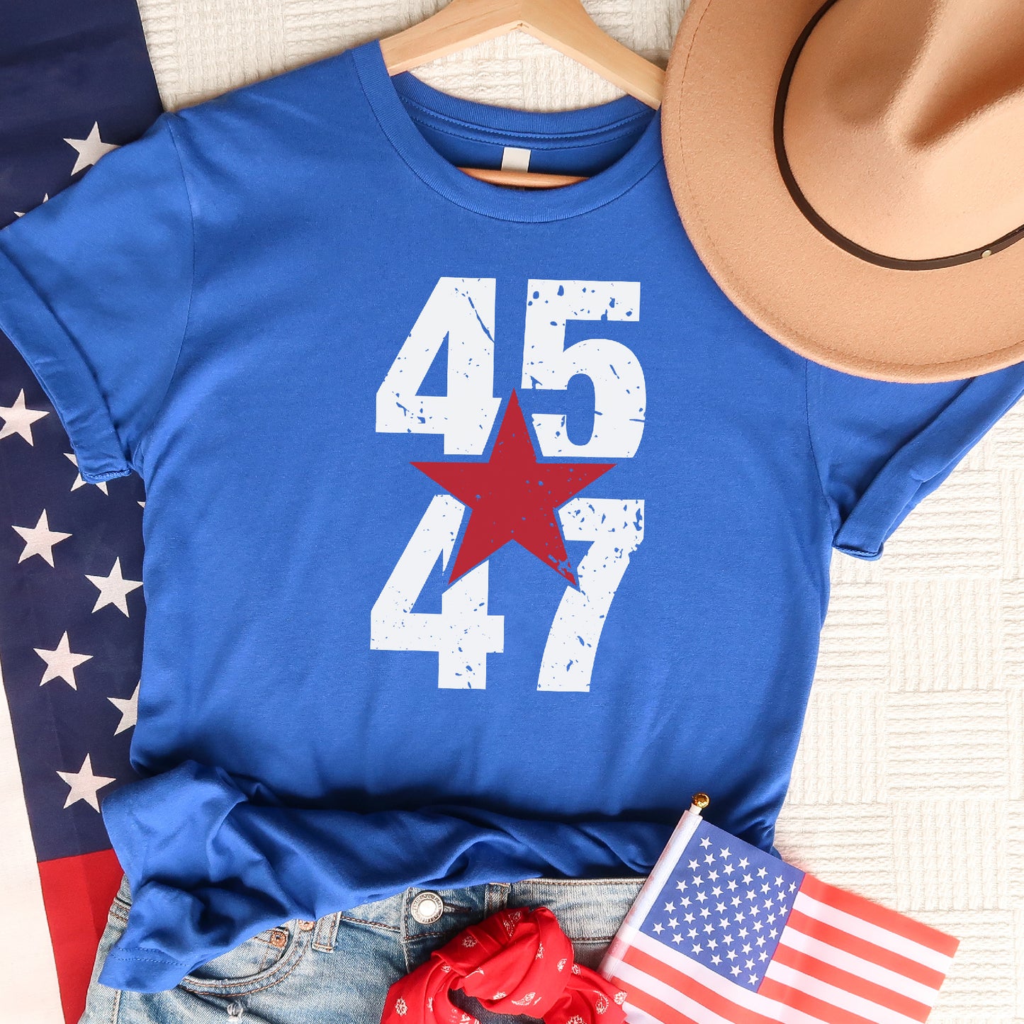 a t - shirt with the number 477 on it next to a cowboy hat