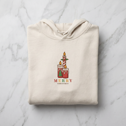 A beige hoodie with a graphic design of two lit candles and the text "MERRY CHRISTMAS" printed on it.